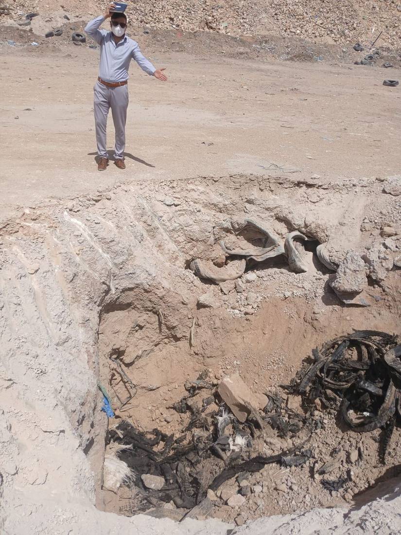 مهندس جي بي آر سيرفي يفحص حفرة اختبارية مكشوفة في موقع دفن الإطارات المخالف، مع بقايا إطارات محروقة ظاهرة